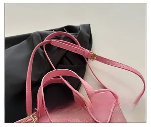 Detail of adjustable pink shoulder strap with golden buckle and textured bucket bag finish