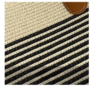 Detailed close-up of woven straw texture with striped patterns and leather accents