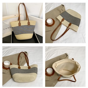 Detail view of woven straw tote bag with navy stripes, leather handles and inner lining