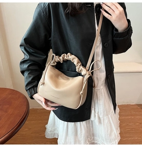 Detail of cream soft leather crossbody bag with cloud pleated handle and fine texture