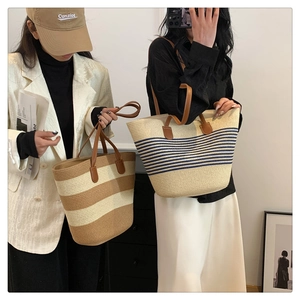 Close-up of woven straw tote bags with leather handles in striped patterns for summer
