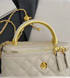 Detail of cream quilted leather bucket bag with gold chain and camellia clasp