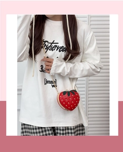 Detail of red strawberry heart crossbody bag with gold studs and chain strap