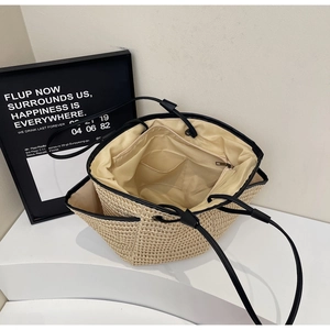 Vue intérieure du grand sac cabas en paille montrant la doublure et la poche zippée