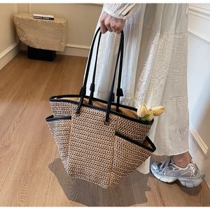 Détail du grand sac cabas en paille tissé à la main avec bordure en cuir noir chic