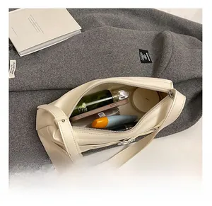 Vue intérieure montrant la grande capacité de rangement de ce sac à bandoulière beige