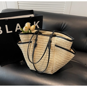 Détail d'un sac cabas en paille tressée avec bordures en cuir noir et doublure interne