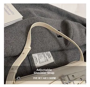 Détail de la bandoulière réglable avec boucle argentée sur un sac en cuir crème
