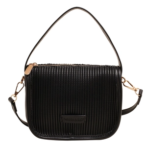 Minimalist black pleated bucket bag with gold hardware and a detachable shoulder strap