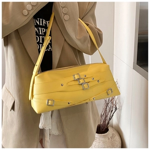 Détail du sac sous le bras jaune avec boucles argentées et lanières en similicuir