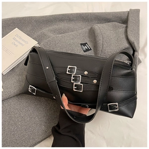 Détail du sac sous le bras en cuir noir avec œillets argentés et lanières de style industriel