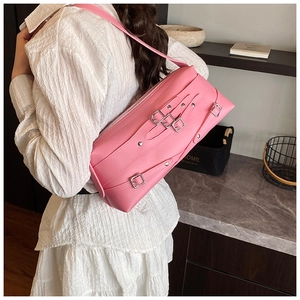 Détail d'un sac sous l'aisselle rectangulaire rose avec boucles argentées et longue sangle