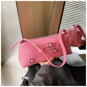 Détail du sac bandoulière rose style motard avec plusieurs sangles et boucles en métal