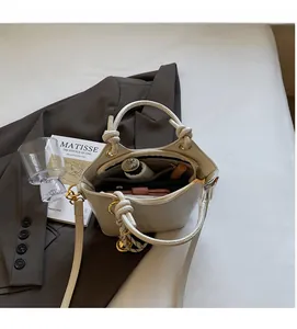 Interior view showing the large capacity and multi-compartment design of the white bucket bag