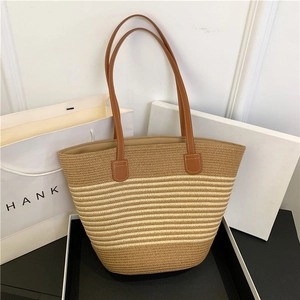 Brown striped woven straw tote bag with leather shoulder straps for summer beach travel