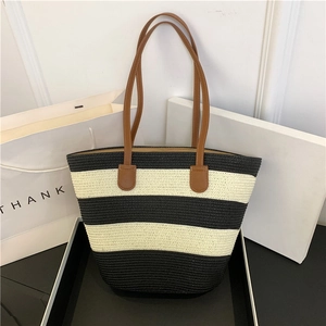 Striped woven straw tote bag with brown leather handles for summer beach vacations