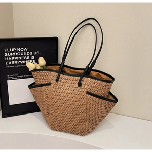 Grand sac cabas en paille tissée avec anses noires sur socle blanc pour vacances à la mer