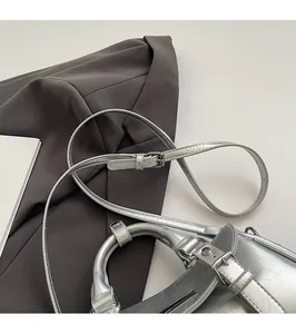 Detail of silver handbag featuring metallic cracked texture and adjustable shoulder strap