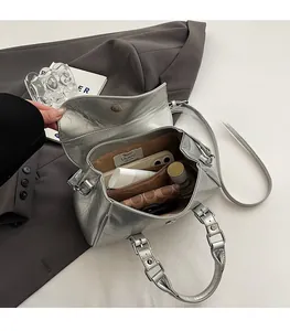 Internal view of silver crossbody bag showing brown lining and storage capacity