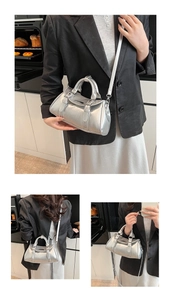 Detail of silver metallic bowling handbag featuring belt buckle accents and dual straps