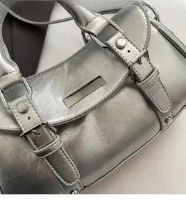 Close-up of metallic silver crinkled texture fabric and hardware details on handbag