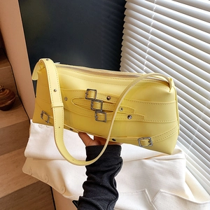 Sac baguette chic en cuir jaune avec boucles argentées, porté épaule ou en bandoulière