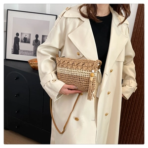 Detail of woven straw bag with striped texture, side tassel, and thin leather shoulder strap