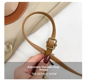 Detail of adjustable brown faux leather shoulder strap with a bronze metal buckle