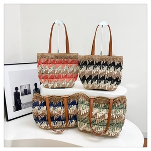 Detail of four colorful woven straw tote bags with leather handles for summer travel