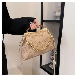 Detail of vintage beige handbag featuring elegant lotus and koi embossed patterns