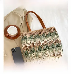 Close-up of contrast color striped straw tote bag with premium brown leather handles