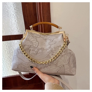 Detail of vintage grey clutch bag featuring embossed fish and lotus leaf patterns