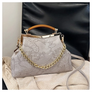 Close-up of vintage frame bag with koi and lotus relief on grey matte leather