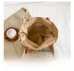 Detail view of straw handbag interior showing lining, zipper pocket and spacious storage