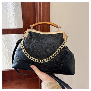 Detail of vintage black bag with embossed carp and lotus patterns and golden chain