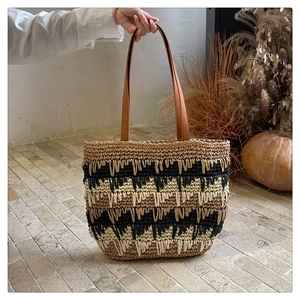 Detail of hand-woven straw tote with tri-color stripes and fringe texture