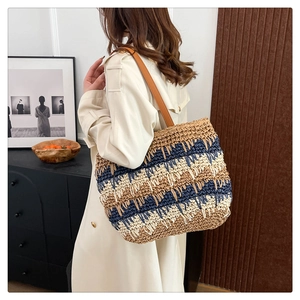 Detail of color-block straw tote bag with brown leather straps and woven texture