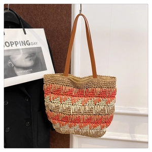 Detail of color-block straw tote bag with striped texture and leather handles