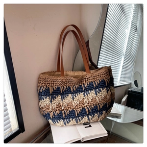 Detail showing wavy color-block woven straw texture and premium brown leather straps