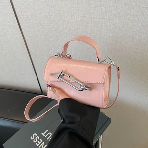 Détail du mini sac en cuir verni rose avec boucle métallique argentée et poignée supérieure