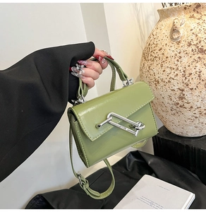 Détail du sac en cuir vert avocat avec un fermoir chaîne géométrique argenté élégant