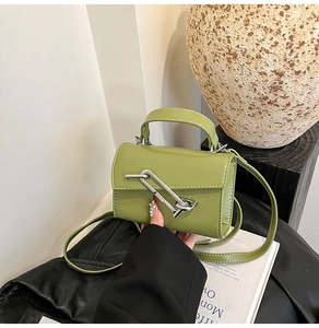 Détail macro du mini sac en cuir vert herbe avec boucle en métal argenté moderne