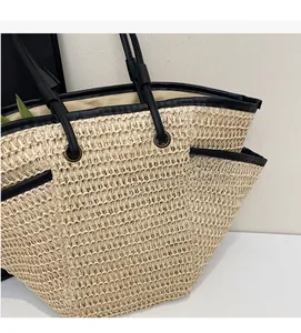 Dettaglio della trama di una borsa tote in paglia con bordi in pelle nera e fibbie