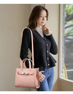 Detailed close-up of a pink litchi texture shoulder bag with silver metal lock closure