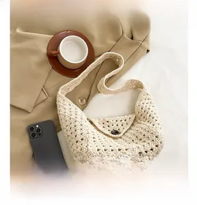 Detail of cream crochet woven bag with button closure and intricate hollow pattern
