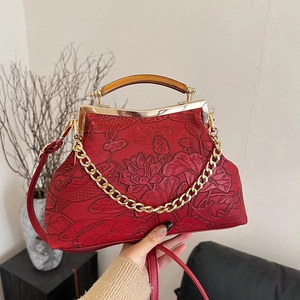 Vintage dark red evening bag with embossed lotus and koi design, featuring amber handle