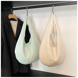 Dettaglio di borse tote in velluto a coste verde menta e beige con bottone a pressione