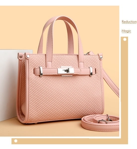 Close-up of pink litchi pattern leather bag with light gold hardware and metal lock