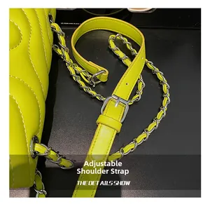 Detail of adjustable leather-woven metal chain strap on green quilted crossbody bag