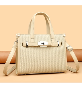 Close-up of beige woven texture and metal rotary lock on the crossbody handbag